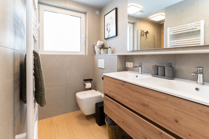 Bad im Obergeschoß mit Doppelwaschbecken, ebenerdigen Dusche, beleuchtetem Spiegel mit Antibeschlagfunktion, WC mit Hygienedusche