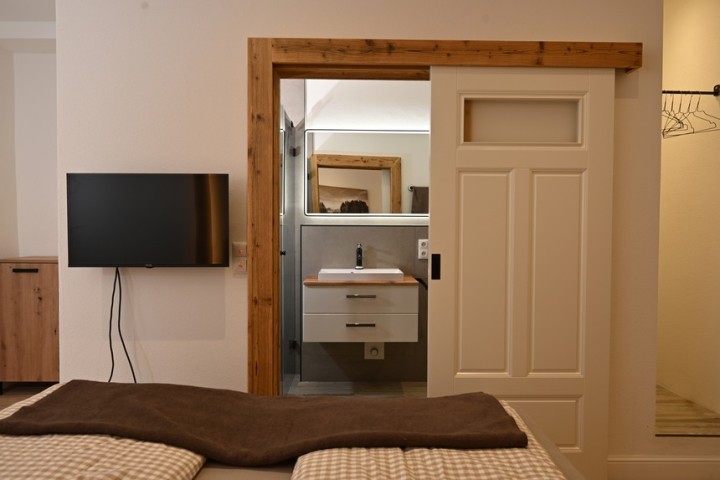 Fernseher und Schiebetür zum Bad-en-Suite