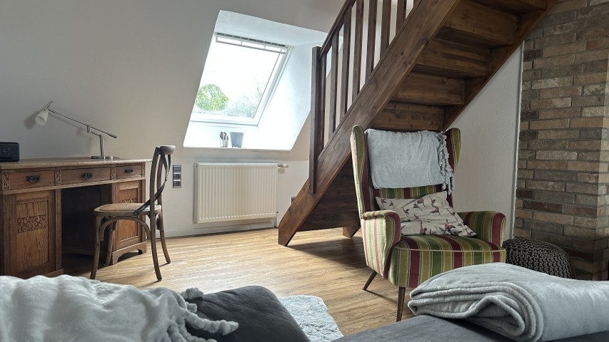 Wohnzimmer mit Treppe zur Schlafetage