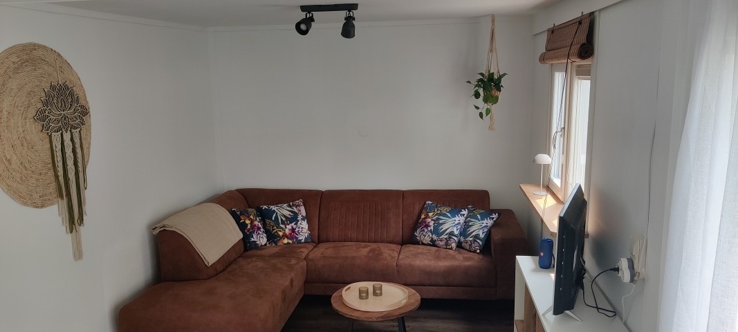 Wohnzimmer mit Ecksofa und Smart TV