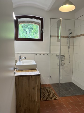 Bad mit Dusche, Waschbecken, Waschmaschine und Trockner