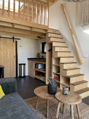 Über die Holztreppe ist der Schlafbereich zu erreichen