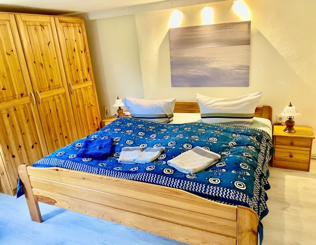 Im Schlafzimmer bietet der große Kleiderschrank viel Stauraum. Das Bett ist aus Holz und knarrt ein bisschen. Im Schlafzimmer bietet der große Kleiderschrank viel Stauraum. Das Bett ist aus Holz und knarrt ein bisschen.