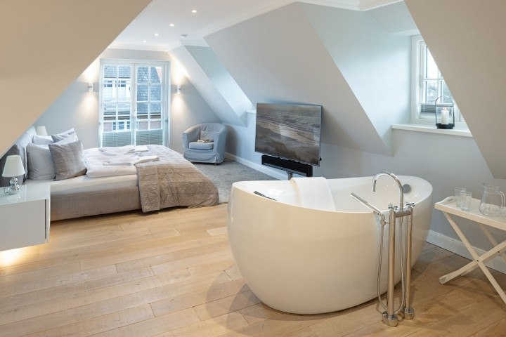 Schlafzimmer eins mit Freistehender Badewanne und Bad en Suite