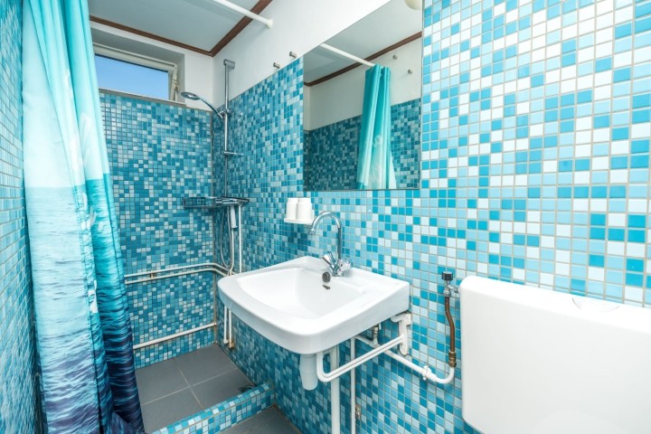 Badezimmer mit Dusche, Waschbecken und Toilette