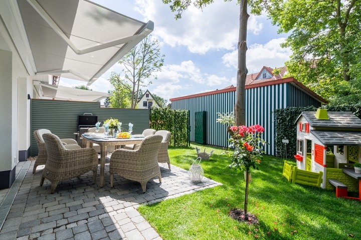 Gartenansicht mit Terrasse und elektrischer Markise