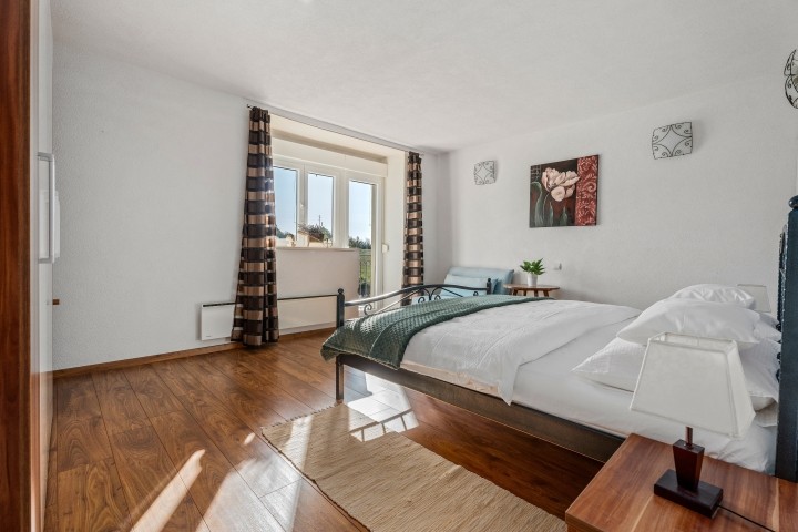 Ein Schlafzimmer Nr. 2 mit einem Kingsize-Bett, einem Sofa, Klimaanlage und einem Balkon mit Blick auf den Pool