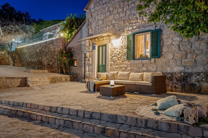 Eine bezaubernde Steinterrasse in der Abenddämmerung, mit warmem Außenlicht