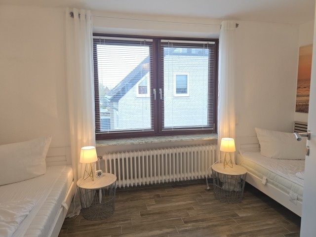 Schlafzimmer mit zwei Einzelbetten und TV