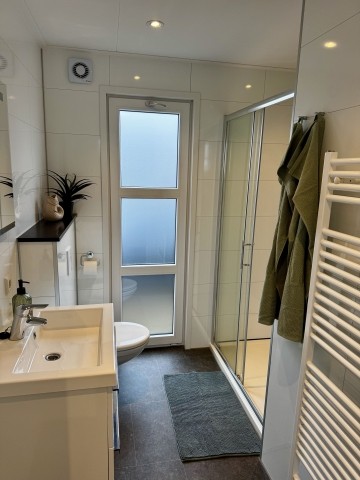 Modernes, helles Bad mit ebenerdiger Dusche