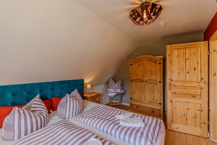 Schlafzimmer mit großem Doppelbett und Blick zum Hochwald