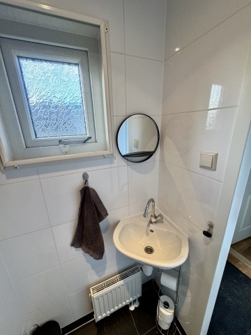 Es ist mit einem Waschbecken und Spiegel ausgestattet