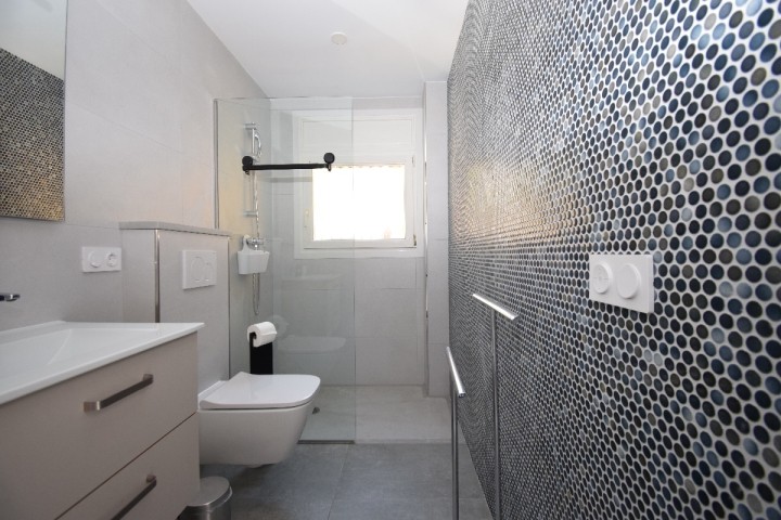 grosses Badezimmer mit ebenerdiger Dusche, WC und Fenster