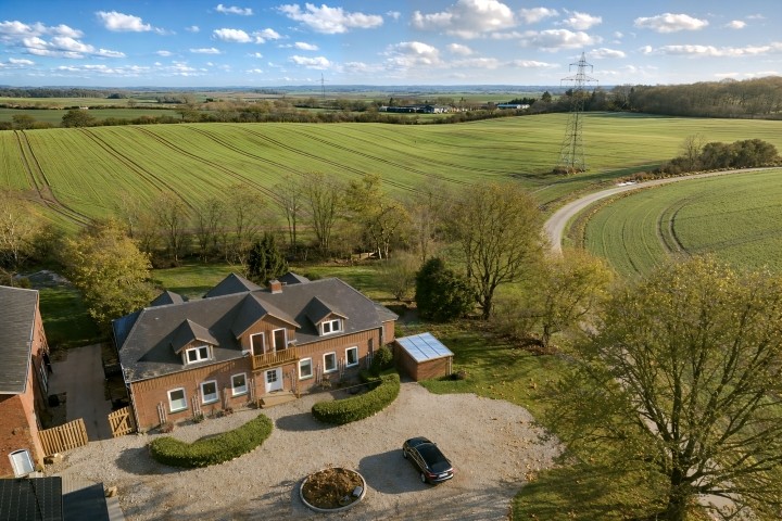 Luftaufnahme Ferienhaus, eingebettet in die hügelige Landschaft