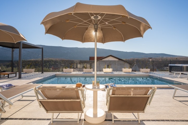 Cozy Lounge area surrounded by sun loungers, a relaxing Jacuzzi, and an outdoor shower.