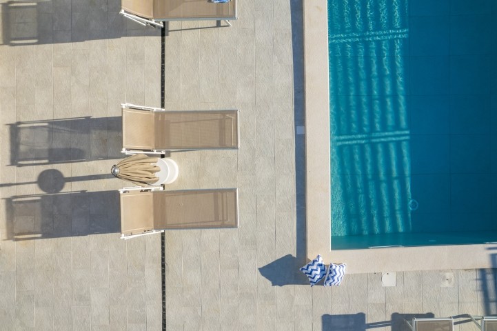 Whether you're basking in the sun, enjoying a leisurely swim, or sipping drinks in the shaded lounge area, this outdoor oasis is perfect for unwinding.