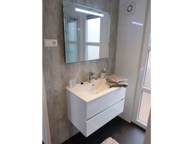 Bad mit ebenerdiger Dusche und Waschbecken