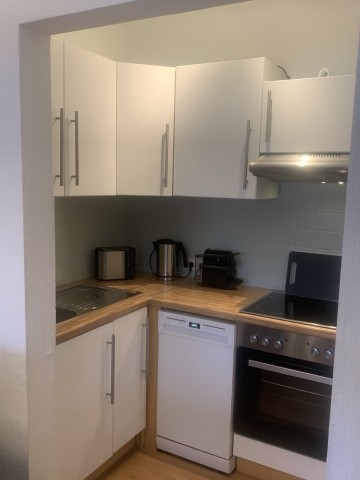 Küche mit Kühl-Gefrierkombi, Herd, Ceranfeld, Geschirrspüler und Haube