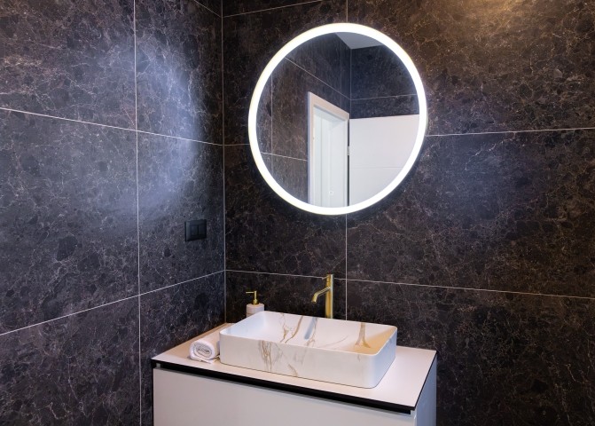 The bedrooms share a modern bathroom with a walk-in shower and contemporary design.