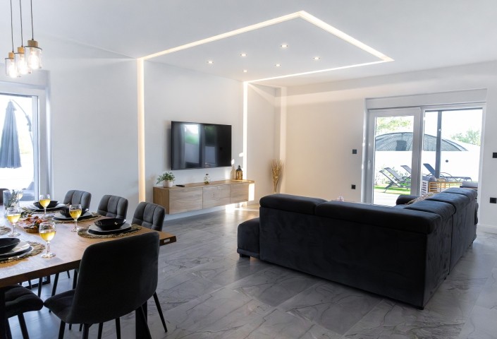 The living room is perfect for relaxing, whether you want to watch TV or enjoy views of the pool.