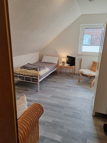 Schlafzimmer mit Einzelbett und Sofa