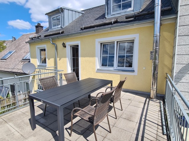 Terrasse zur Wohnung mit großem Sonnenschirm.