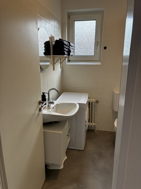 Badezimmer mit Dusche, Waschbecken und Spiegel