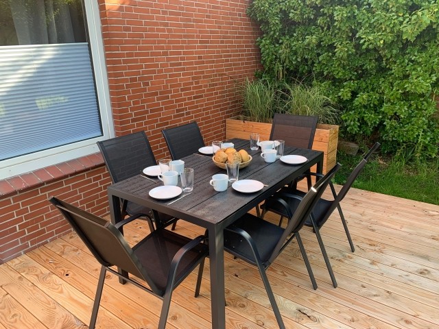 Terrasse mit Esstisch und Zugang zum Garten