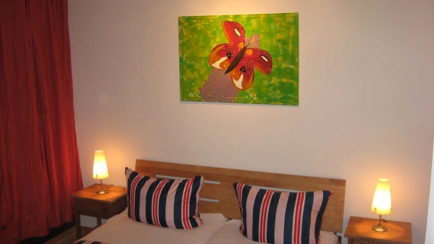 Hier sehen Sie eines der 3 Schlafzimmer. Alle haben ein Doppelbett und bieten Platz für 6 Personen. 2 der Schlafzimmer haben Terrassenelemente. Sie kommen direkt auf die untere Terrasse und dem Garten. Wer hat das schon? Das Duschbad mit begehbarer grosse