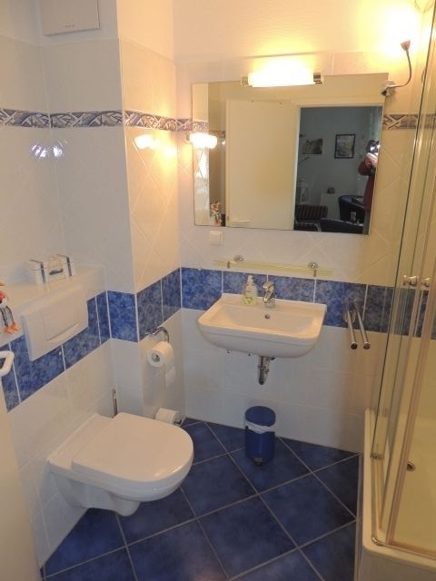 randlose Toilette und Glaskabine mit Regendusche