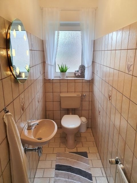 Toilette mit Waschbecken und beleuchtetem Spiegel