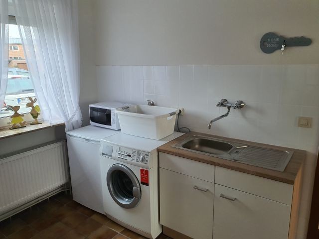 Waschküche mit Waschmaschine, extra Spüle und Gefrierschrank sowie Mikrowelle