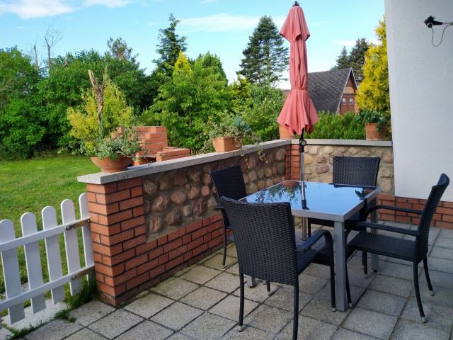 Terrasse mit Tisch, Stühlen und Sonnenliegen