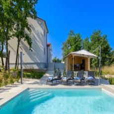 Ferienhaus mit Pool und umgeben von viel Grün
